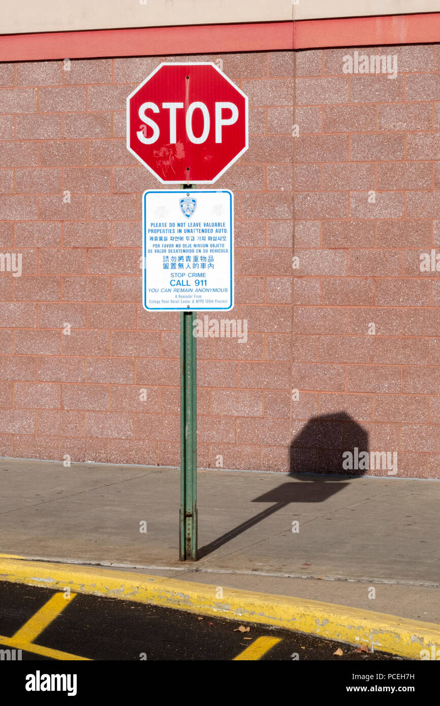 Une inscription de la fonction publique dans un centre commercial Queens les conducteurs d'avertissement en 4 langues, pour ne pas laisser des objets de valeur sans surveillance dans les voitures. Banque D'Images