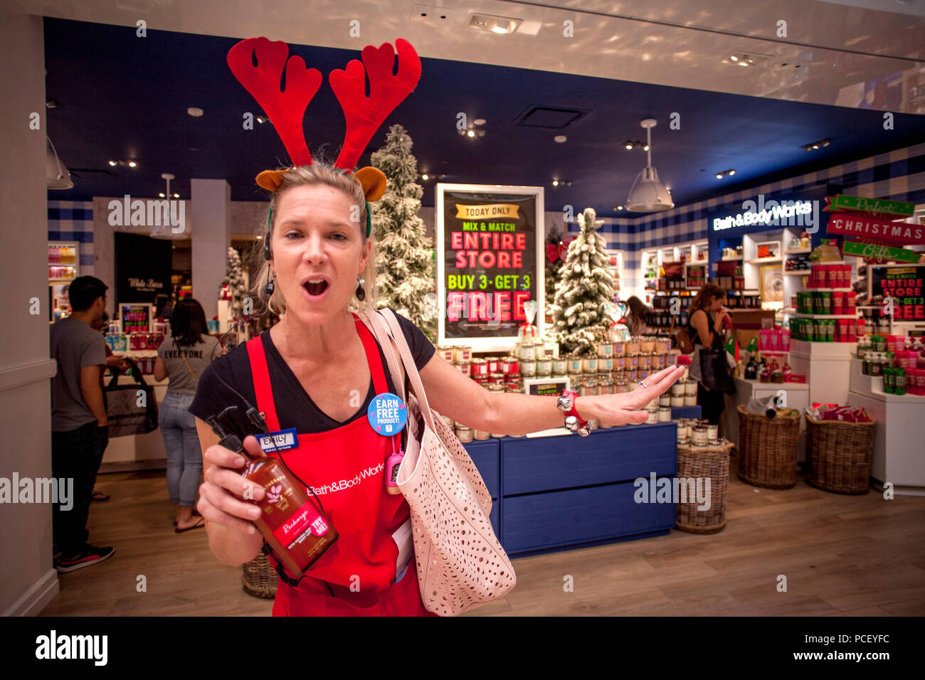 Wearing red reindeer antlers, une personne de ventes encourage les acheteurs vendredi noir avec une remise de prix à un des articles personnels dans un magasin Costa Mesa, CA, centre commercial. Banque D'Images