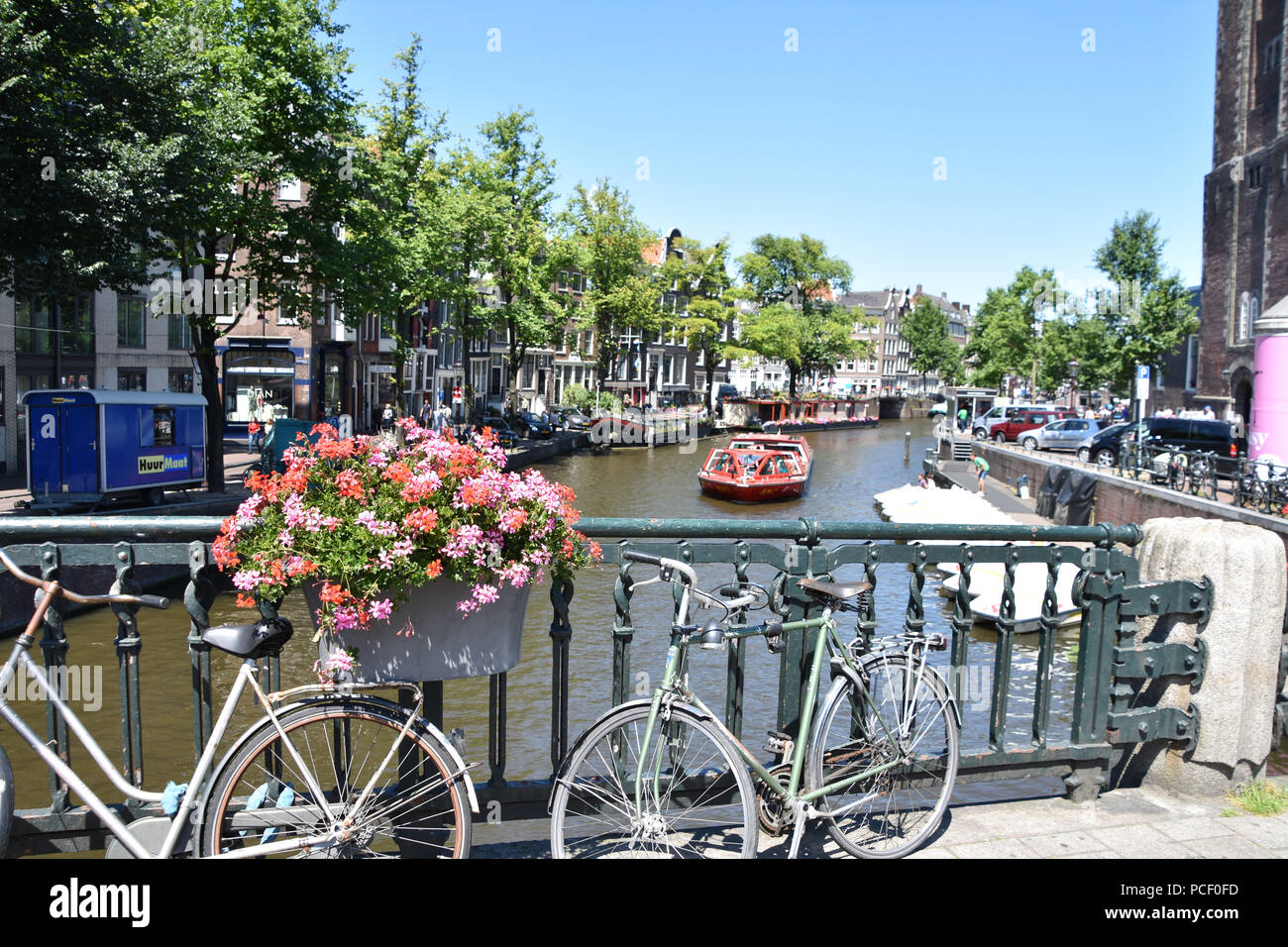 Des fleurs, des bicyclettes et un bateau d'excursion sur l'un des nombreux canaux d'Amsterdam. Juin, 2018 Banque D'Images