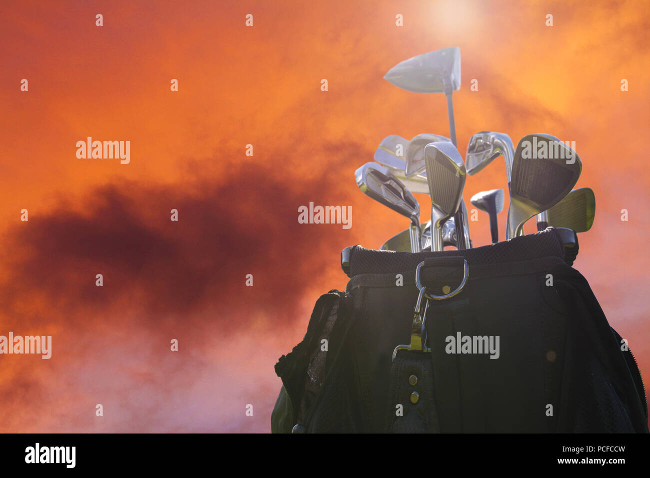 Close up d'un sac de golf avec des clubs contre un ciel de coucher du soleil Banque D'Images