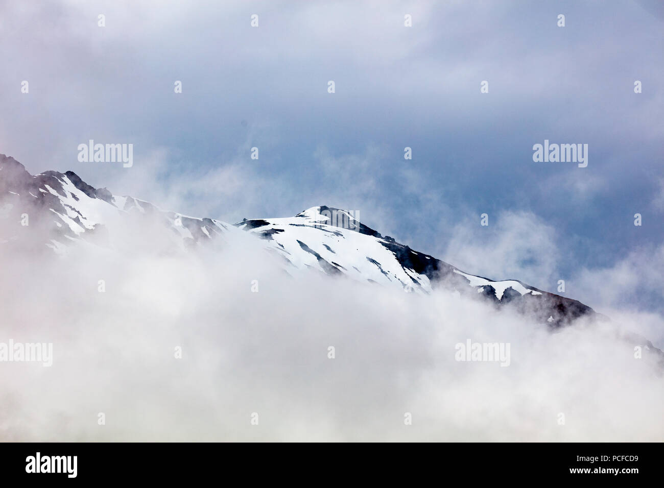 Enneigés des montagnes rocheuses dans les nuages sur la péninsule de Kenai en Alaska Banque D'Images