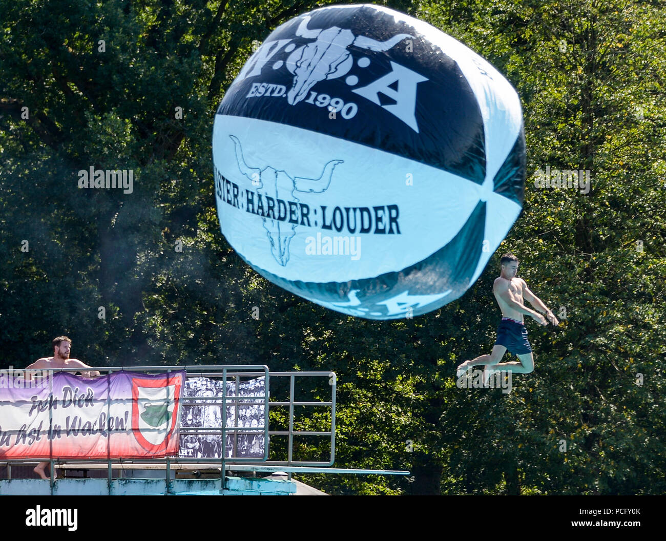 02 août 2018, Wacken, Allemagne : Les Visiteurs du Wacken Open Air de s'amuser dans la piscine et sauter dans l'eau. Selon les organisateurs, le plus grand festival de heavy metal commence avec 75 000 visiteurs. Photo : Axel Heimken/dpa Banque D'Images