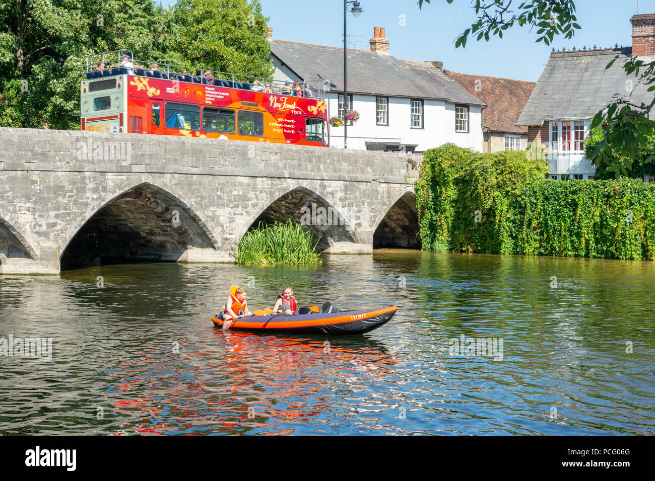 Enfants jouant à bord d'un canot pneumatique sur une rivière par temps chaud, Royaume-Uni Banque D'Images