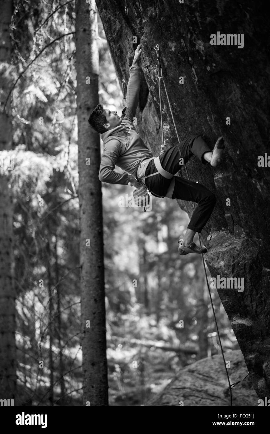 Sport extrême de l'escalade. Rock climber luttes pour le succès. Vie de plein air. Forêt du Nord de la Scandinavie, de destination de voyage. Banque D'Images