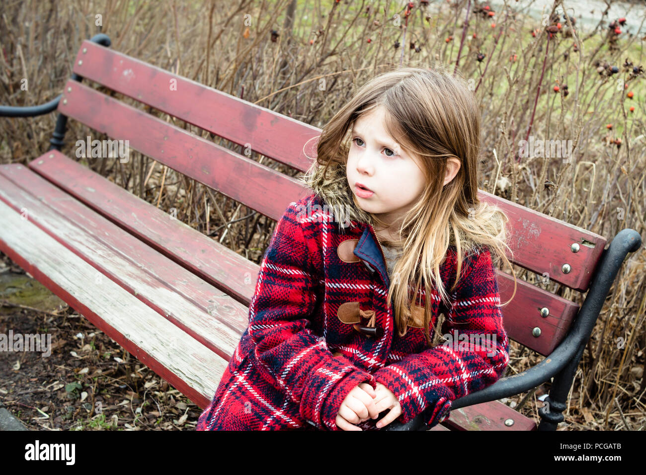 Pâle jeune fille blanche laissé seul sur le banc de parc en hiver. Banque D'Images