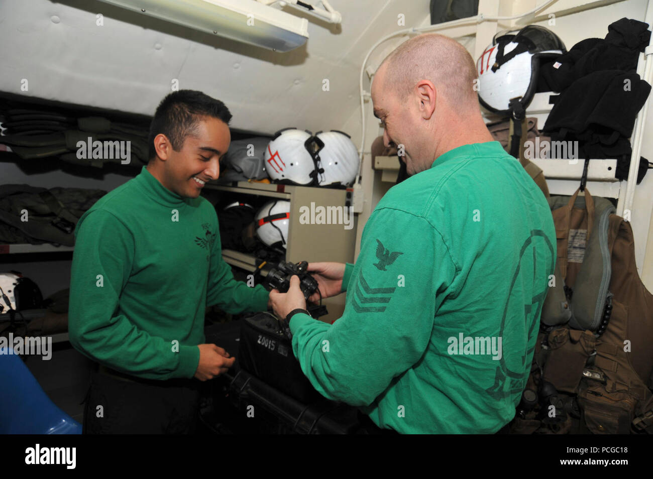 La survie de l'équipage de la Marine américaine Equipmentman aviateur Victor Romero, à gauche, et la survie des équipages de 1ère classe Equipmentman Bruce Pearson, tous deux affectés à l'Escadron d'hélicoptères de combat de la mer (HSC) 9, vérifier des lunettes de vision de nuit avant les opérations de vol à bord du porte-avions USS George H. W. Bush (CVN 77) Juin 27, 2014, dans le golfe Persique. Le navire en charge les opérations de sécurité maritime et les efforts de coopération en matière de sécurité dans le théâtre dans la 5e Flotte des États-Unis zone de responsabilité. Banque D'Images