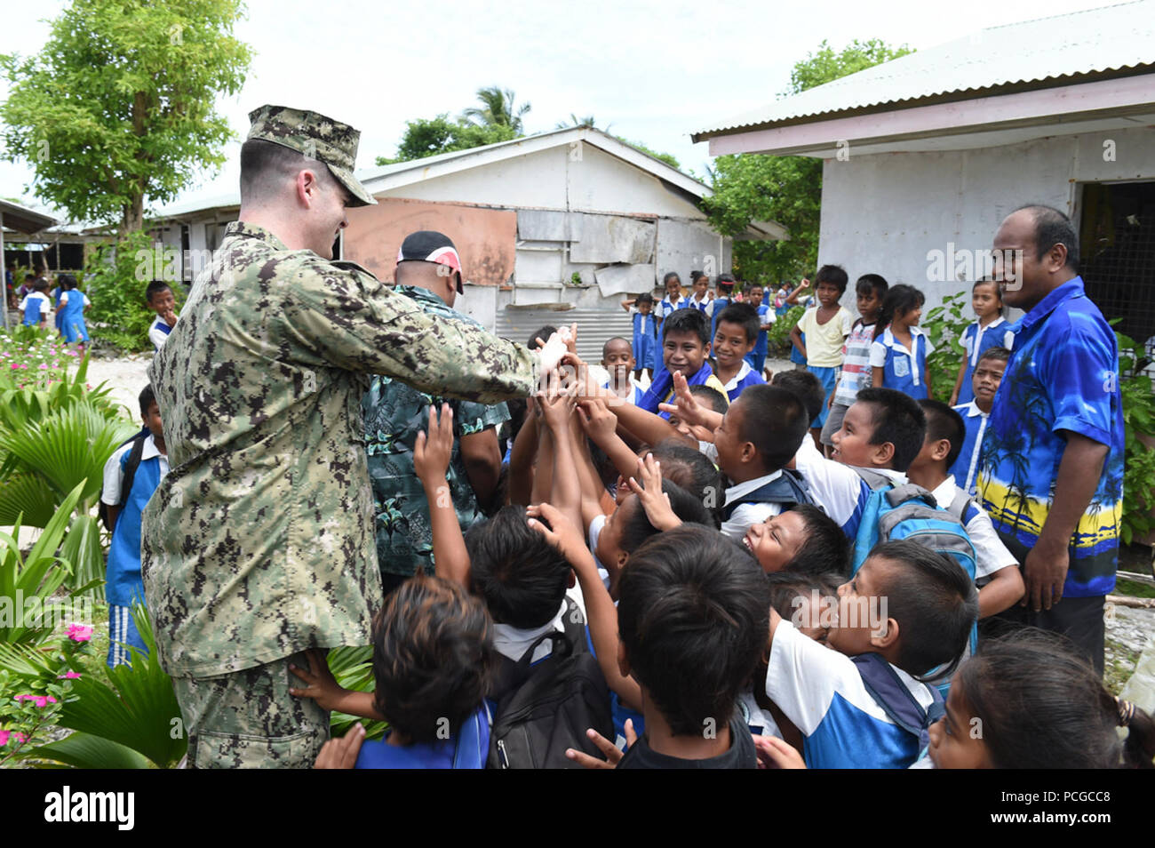 TARAWA, Kiribati (19 mai 2015) Le lieutenant ingénieur parti avancée j.g. William Marchand high fives les élèves de l'école primaire de l'Ouest Bikenibeu lors d'une prospection dans un futur site de construction de Partenariat du Pacifique 2015. Partenariat du Pacifique est dans sa 10ème itération et est la plus grande rencontre annuelle l'aide humanitaire multilatérale et des secours de la protection civile a effectué une mission dans la région du Pacifique-Indo-Asia. Bien que l'entraînement pour des conditions de crise, Partenariat du Pacifique date de missions ont fourni des soins médicaux à environ 270 000 patients et des services vétérinaires pour les animaux de plus de 38 000 Banque D'Images