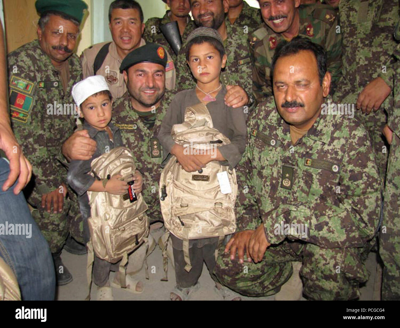 Afghan Air Force et soldats de l'Armée nationale afghane de la 209e Corps canadien participent à leur première mission humanitaire en distribuant des fournitures scolaires aux enfants dans un village près de Mazar e Sharif, Afghanistan, le 27 juillet, 2010 Banque D'Images
