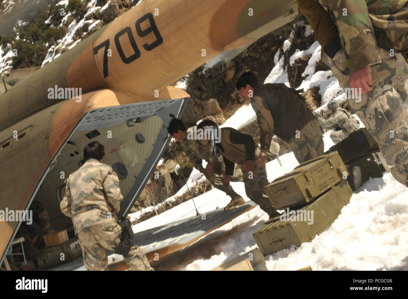 Les troupes de la Police nationale afghane, supprimer les dispositions de l'arrière d'un Afghan Air Force l'hélicoptère de transport Mi-17 au cours d'une mission de ravitaillement de combat en barge Matal dans le nord de la vallée de la Kunar, 10 mars. L'Afghan Air Force a travaillé en coopération avec le ministère de l'intérieur et les forces de la coalition pour terminer la mission, à l'aide de dix avions pour offrir plus de 9 000 kilogrammes d'armes, de munitions et de vivres à la Police nationale afghane stationnée dans le poste distant qui est considérée comme essentielle par les responsables afghans en raison de sa proximité avec le Pakistan et l'histoire de l'activité des insurgés. Après la chute de l'offre, Banque D'Images