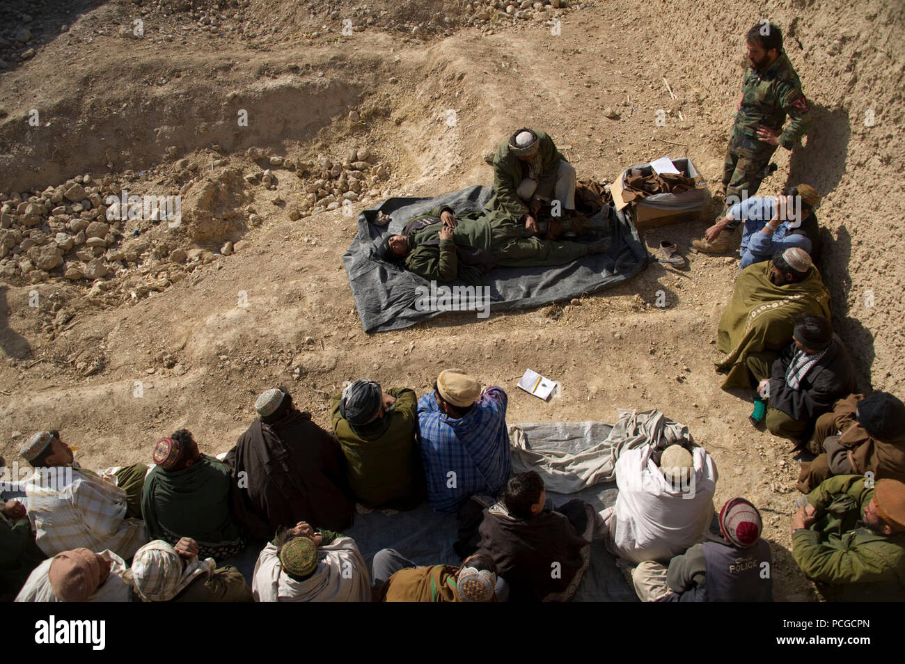 Une police locale afghane candidat montre comment appliquer une attelle pour camarades de classe lors d'une première classe d'aide dans Kajran Daykundi district, province, Afghanistan, janv. 5. Les trois semaines de l'ALP cours couvre les procédures de police de base, le maniement des armes et les autres compétences nécessaires pour protéger et défendre les citoyens afghans et de maintenir la stabilité dans la région. Banque D'Images