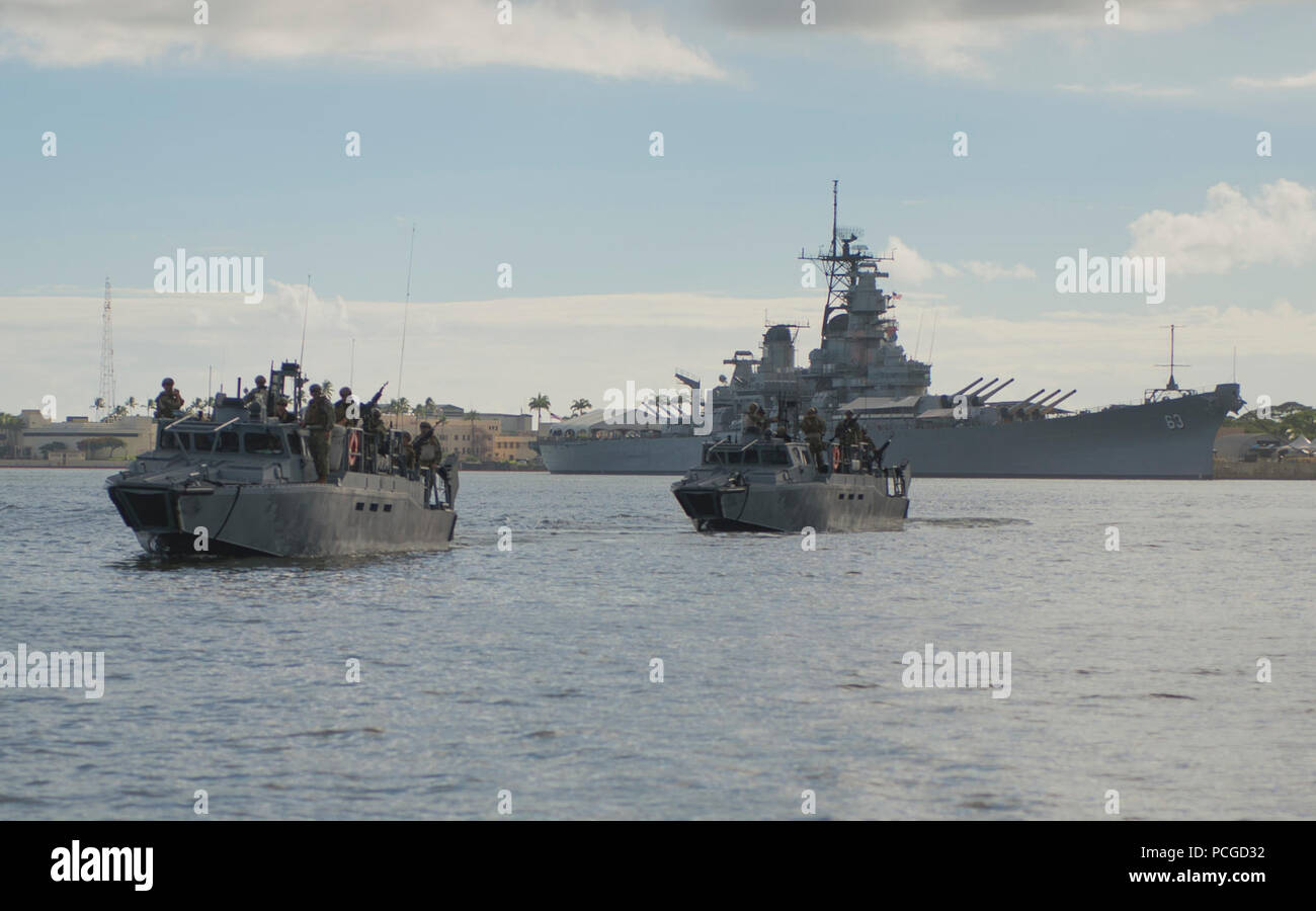 BASE COMMUNE de Pearl Harbor, Hawaï (HICKAM Juillet 24, 2016) - Les marins de la côte de l'Escadron de Trois Rivières (CRS-3) Commande fluviales des bateaux (RCB) passent devant l'USS Missouri (BB-63) à Pearl Harbour. Les marins se préparaient à un exercice visant à défendre l'USNS Rainier (T-AOE 7) à partir d'une attaque simulée comme il s'écarte à l'appui de navires pour le Rim of the Pacific 2016. Vingt-six nations, comprenant plus de 40 navires et sous-marins et plus de 200 avions et 25 000 personnes participent à l'EXERCICE RIMPAC du 30 juin au 4 août dans et autour des îles Hawaï et la Californie du Sud. L'ONU fournit un RIMPAC Banque D'Images