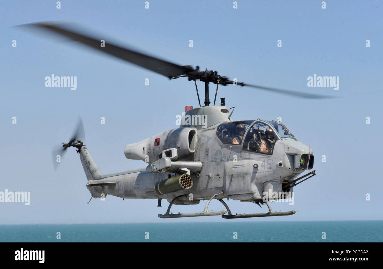 Océan (10 avril 2013) l'Aviation maître de Manœuvre des trains de 3e classe Joseph Grippo sous un avion polyvalent de l'enseignement directeur d'assaut amphibie USS Iwo Jima (DG 7) pendant les opérations de vol à bord du navire d'assaut amphibie polyvalent USS Bataan (DG 5). Le AH-1W Super Cobra c'est affecté à l'Escadron (Light-Helicopter Marine HMLA) 167. Bataan est en cours la réalisation d'opérations de formation et de qualifications. Banque D'Images