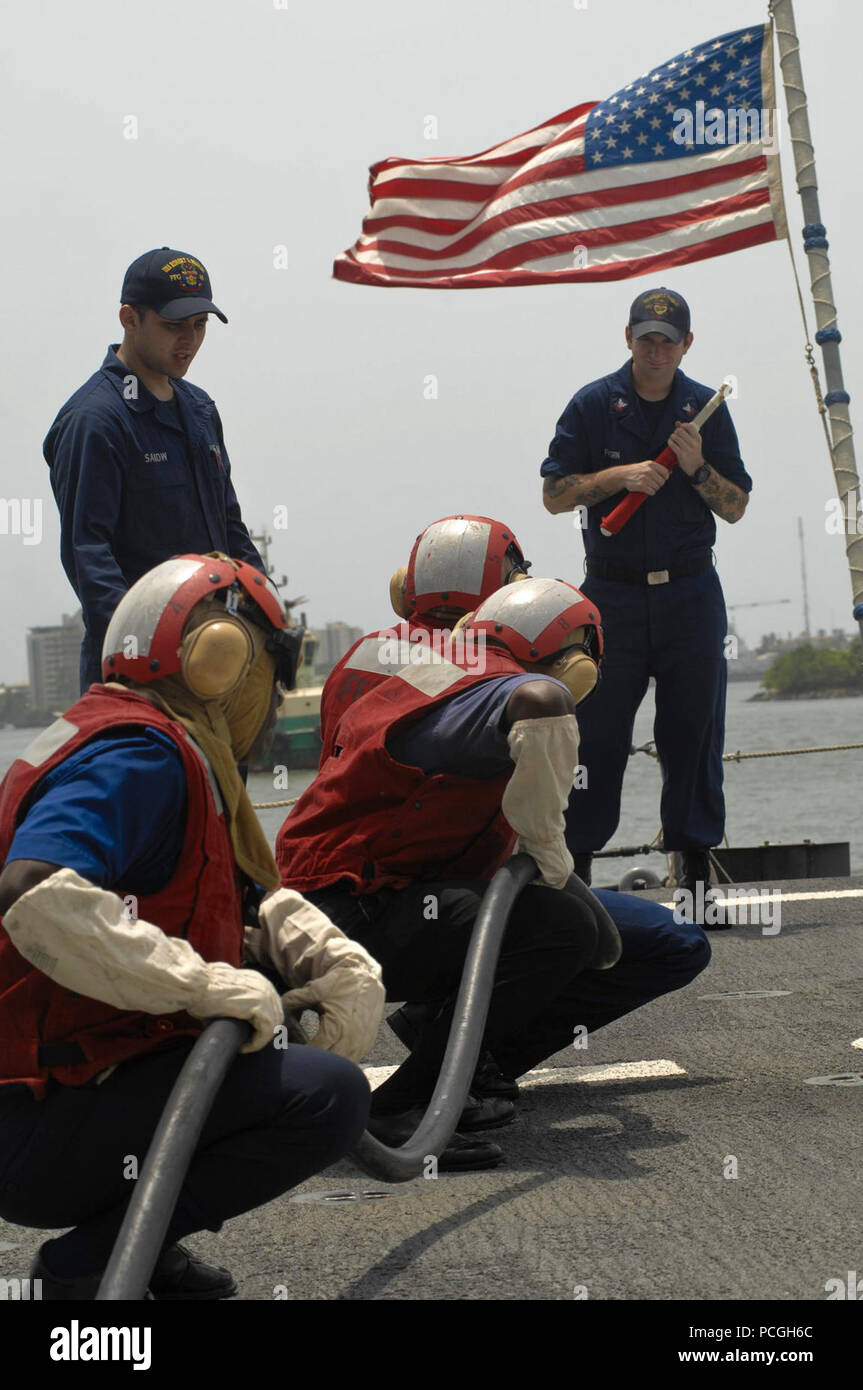 Demandez aux marins une équipe de lutte contre les incendies nigérian au cours d'un exercice de contrôle des avaries à bord du USS Robert G. Bradley comme partie de l'Afrique de l'Ouest Station Partenariat dans le port de Lagos. L'APS est une initiative de coopération internationale de sécurité, facilité par Commander, U.S. Naval Forces Europe-Africa, visant à renforcer les partenariats maritime mondial par le biais de la formation et des activités de collaboration afin d'améliorer la sécurité maritime et la sécurité en Afrique. Banque D'Images