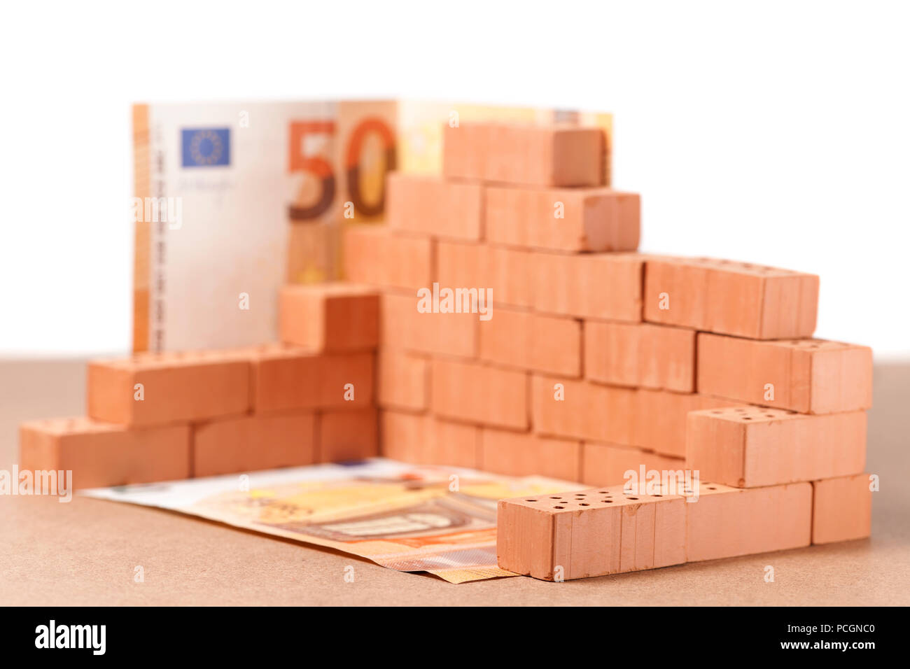 Low Angle View Stacked Toy Brick Building Block avec 50 projets de l'Euro à l'angle et la masse sur sur panneau contre l'arrière-plan blanc. Banque D'Images