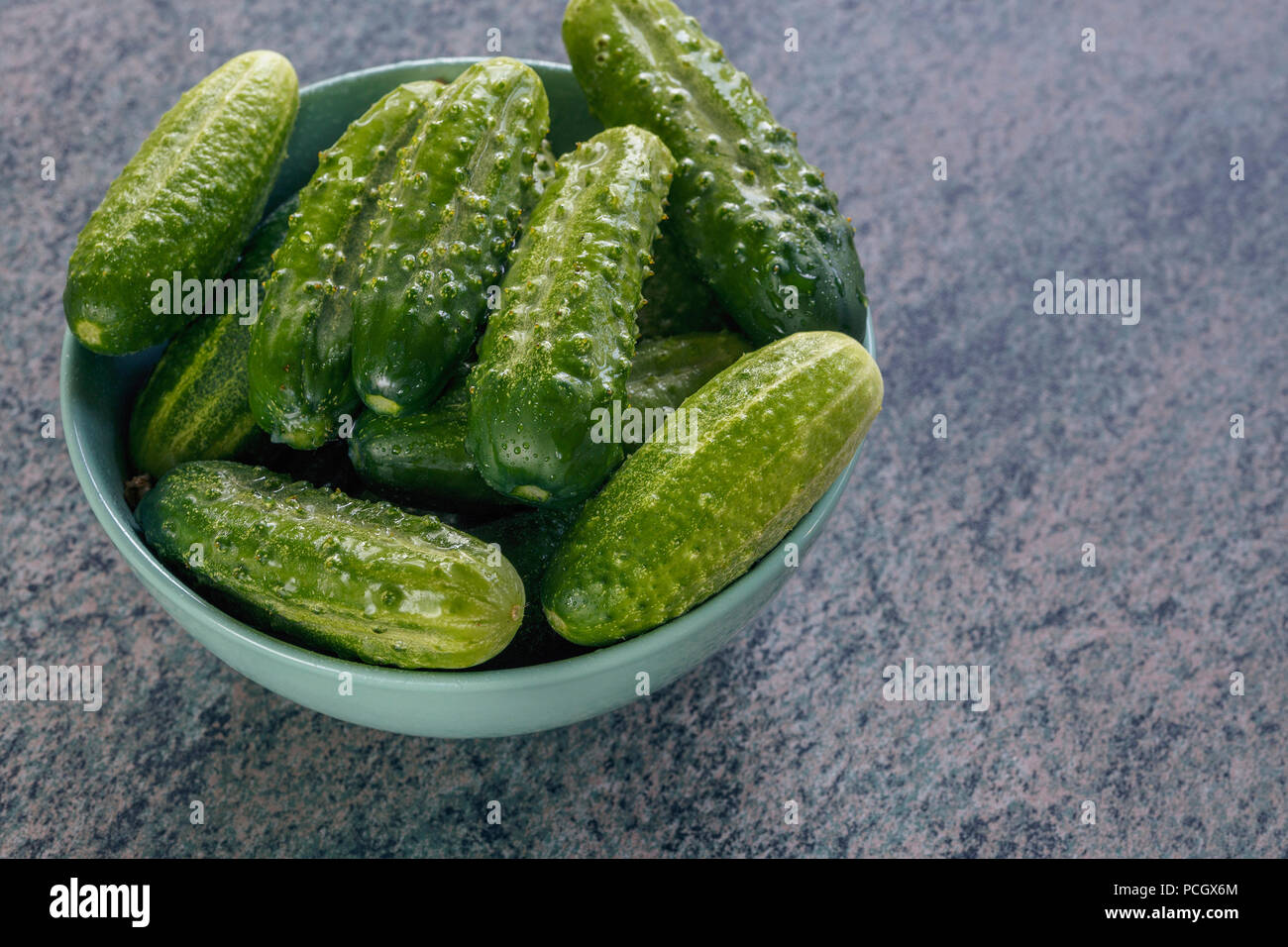 Vue de dessus de concombres dans un bol en céramique, préparé pour le marinage. Le concept de la conservation des aliments pour l'hiver Banque D'Images
