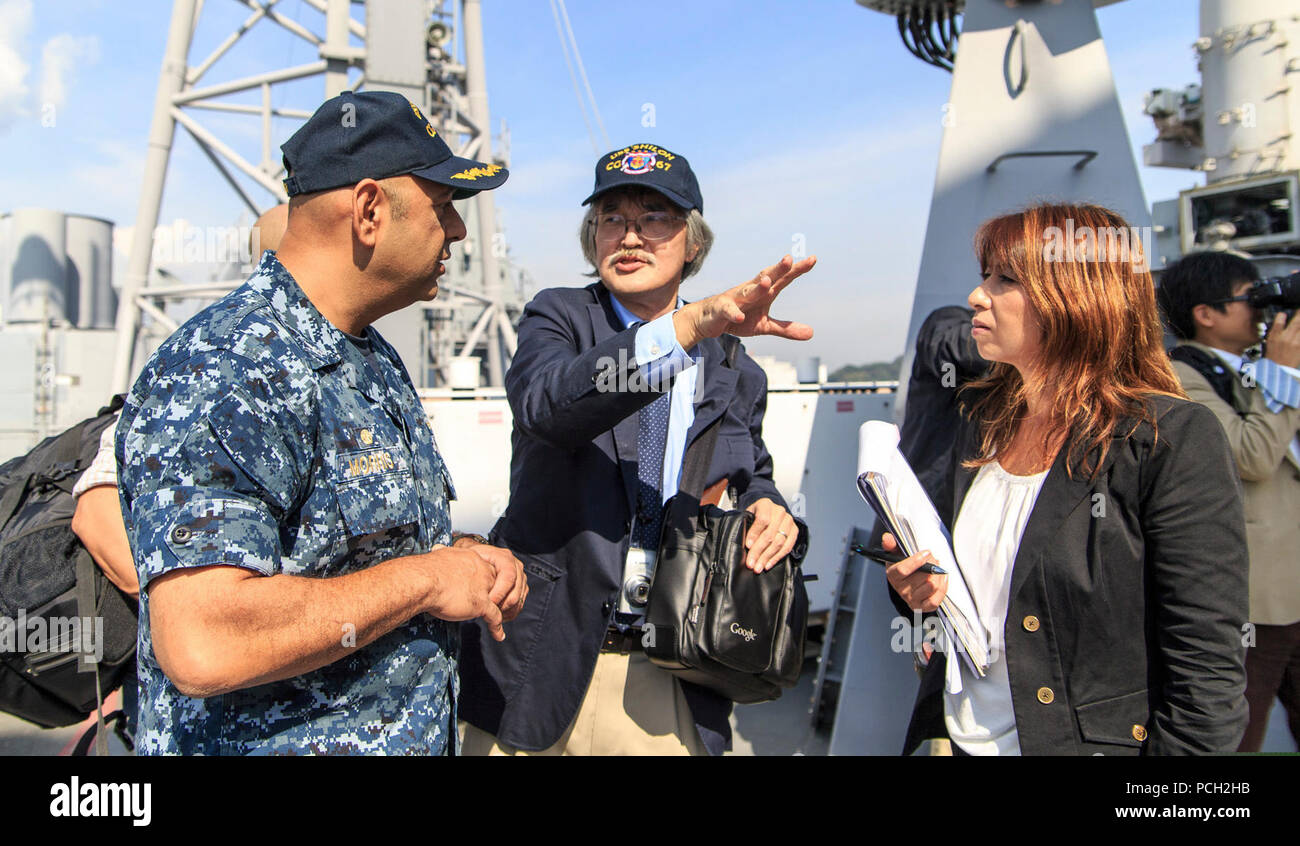 Un journaliste japonais demande le Capitaine de vaisseau américain Morris Kurush, gauche, le commandant de l'cruiser lance-missiles USS Shiloh (CG 67), une question au cours d'une visite du navire à Yokosuka, Japon, 20 octobre 2014. Banque D'Images