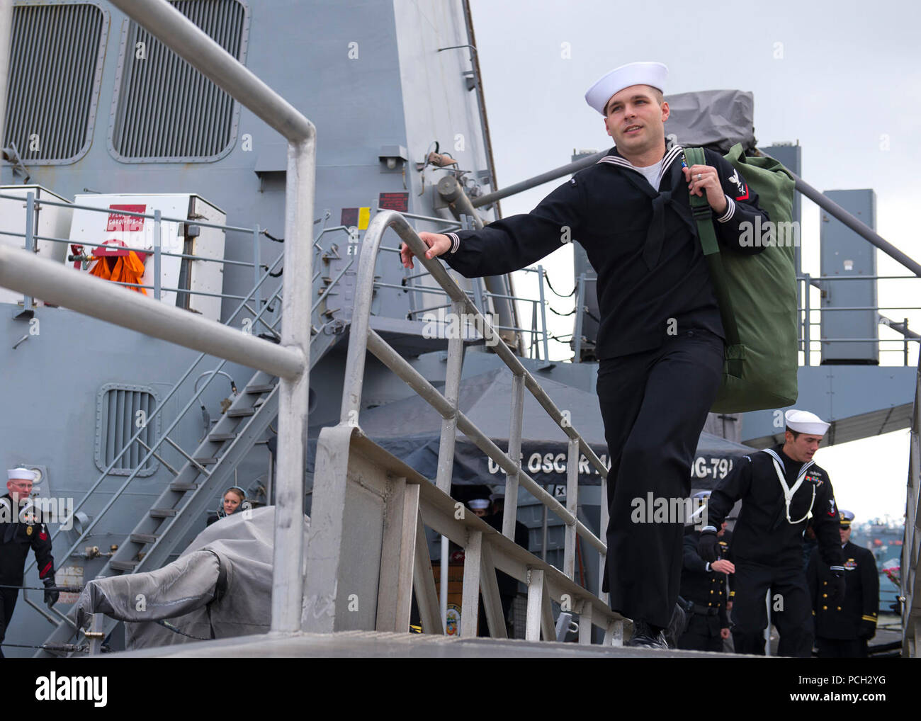 La NORFOLK (fév. 17, 2013) Les marins traversent le front de la classe Arleigh Burke destroyer lance-missiles USS Oscar Austin (DDG 79) après le retour du navire à Norfolk Naval Station après un déploiement de sept mois. Oscar Austin a été déployée à l'appui d'opérations de la sécurité maritime et les efforts de coopération en matière de sécurité dans le théâtre américain dans la zone de responsabilité de la sixième flotte. Banque D'Images