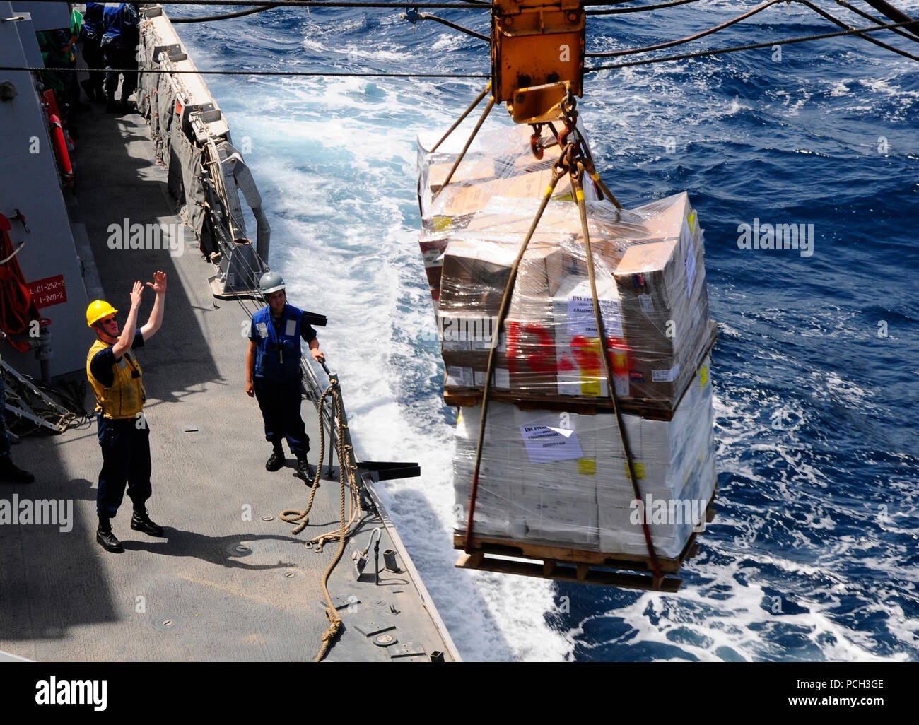 Mer (26 avril 2012) BoatswainХs Mate 2e classe Cory Johnson signale une palette cargo à travers une ligne téléphonique et de la distance au cours d'un ravitaillement en mer à bord du destroyer lance-missiles USS Sterett (DDG 104). Sterett est déployée dans le cadre de l'Abraham Lincoln à la 5e Flotte des États-Unis zone de responsabilité des opérations de sécurité maritime, les efforts de coopération en matière de sécurité dans le théâtre et missions d'appui dans le cadre de l'opération Enduring Freedom. Banque D'Images