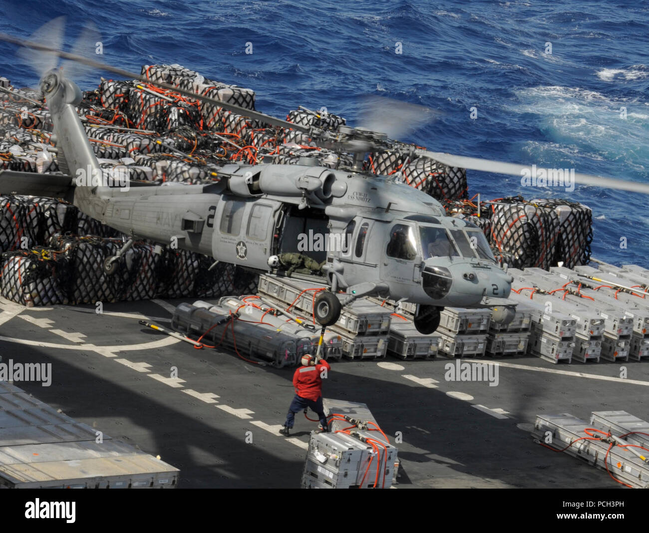 Océan Pacifique (28 avril 2013) Un membre d'équipage à bord du transport maritime de marchandises sèches commande militaire et des munitions ship USNS Richard E. Byrd (T-AKE 4) attache une cargaison à un MH-60S Sea Hawk affecté à l'hélicoptère de combat indiens de la mer de l'Escadron (HSC) 6 lors d'un ravitaillement en mer avec le porte-avions USS Nimitz (CVN 68). Nimitz et Carrier Air Wing 11 quitté San Diego pour un déploiement de l'ouest du Pacifique. Banque D'Images