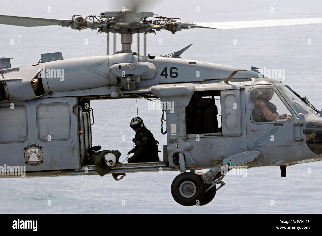 Un U.S. Navy aircrewman contrôle le chargement d'une poignée de MH-60S hélicoptère Seahawk affectés à l'Escadron d'hélicoptères de combat de la mer (HSC) 23 au cours d'un ravitaillement vertical en mer entre le navire de soutien de combat rapide USNS Bridge (T-AOE 10) et station d'amphibie Navire de débarquement USS Comstock (LSD 45) dans la région du Golfe, le 17 mai 2011. Comstock a appuyé les opérations de sécurité maritime et les efforts de coopération en matière de sécurité dans le théâtre dans la 5e Flotte des États-Unis zone de responsabilité. Banque D'Images