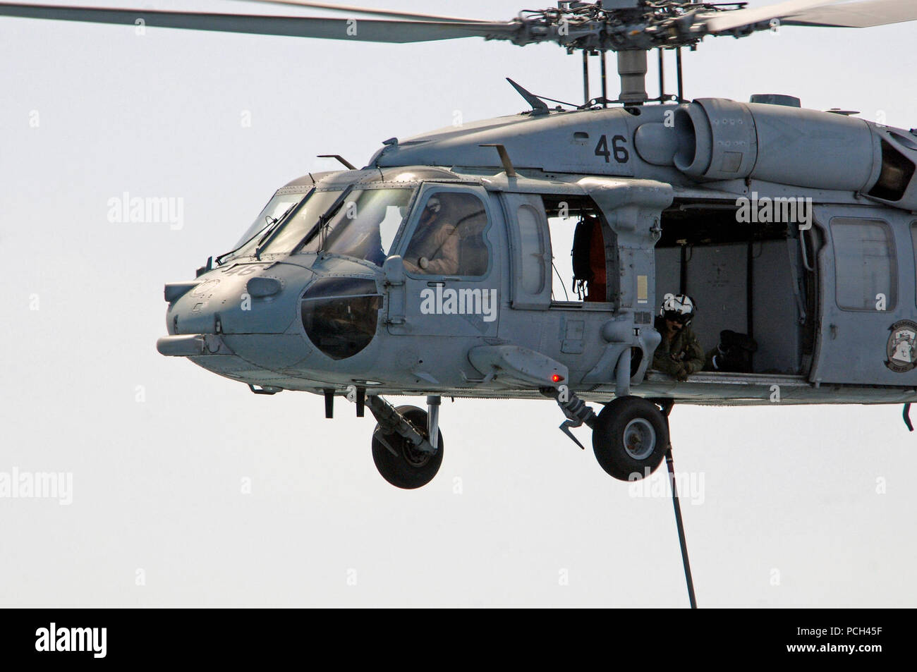 Un U.S. Navy Naval Air Crewman donne à partir d'un hélicoptère MH-60S Seahawk affectés à l'Escadron d'hélicoptères de combat de la mer (HSC) 23 transport des fournitures pendant un ravitaillement vertical entre le navire de soutien de combat rapide USNS Bridge (T-AOE 10) et station d'amphibie Navire de débarquement USS Comstock (LSD 45) dans le golfe Persique, le 17 mai 2011. Martin était en cours d'appuyer les opérations de sécurité maritime et les efforts de coopération en matière de sécurité dans le théâtre dans la 5e Flotte des États-Unis zone de responsabilité. Banque D'Images