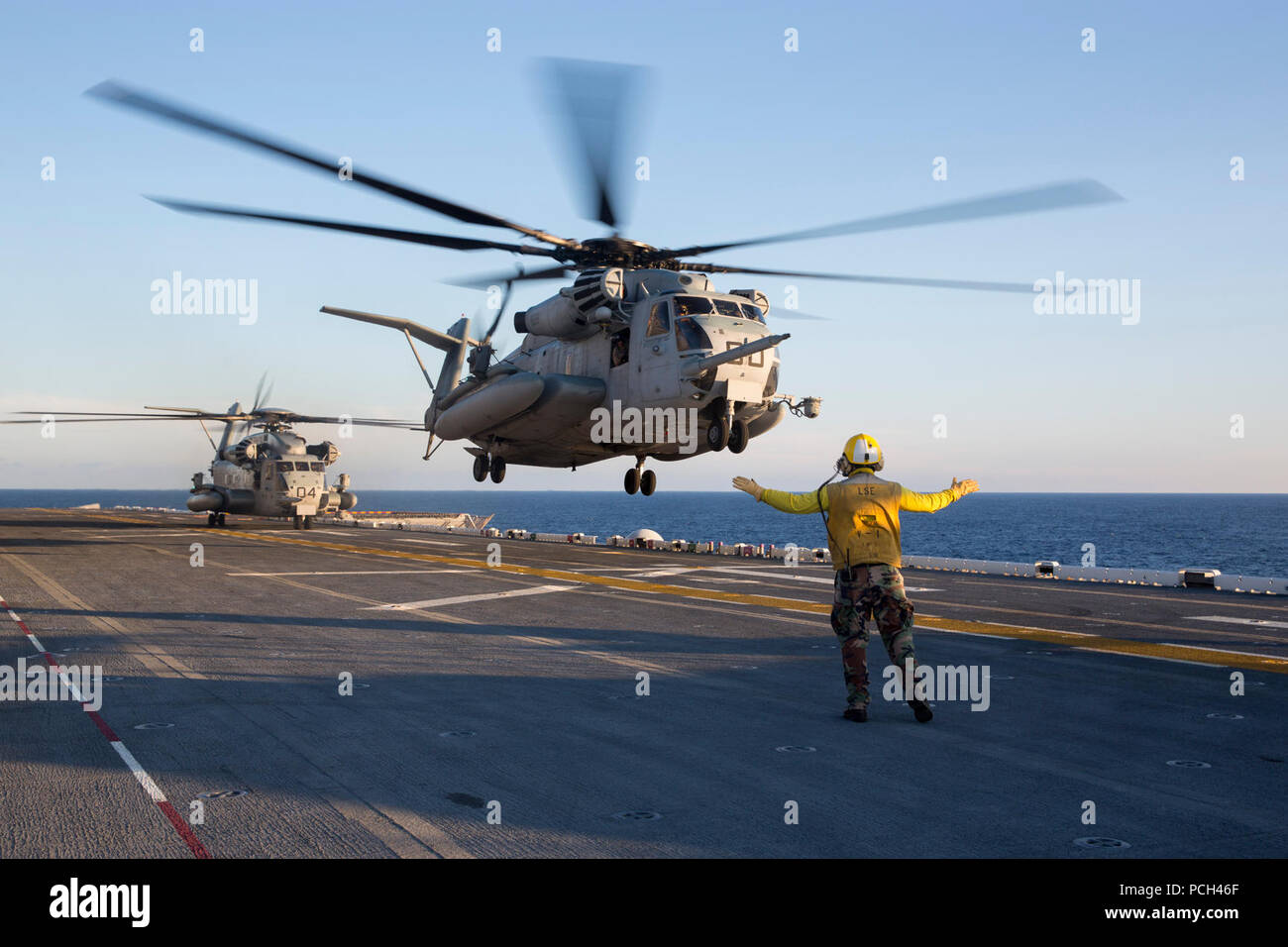 Un marin américain dirige un Marine Corps CH-53E Super Stallion hélicoptère à décoller de l'assaut amphibie USS Kearsarge LHD (3) dans l'Océan Atlantique le 21 septembre 2014. Le Kearsarge était en cours d'effectuer des essais en mer. Banque D'Images