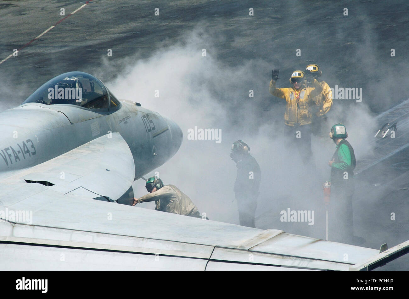 Un avion des signaux gestionnaire d'un pilote de l 'chiens' Pukin' de Strike Fighter (VFA) Sqaudron 143 dans le poste de pilotage de la classe Nimitz porte-avions USS Dwight D. Eisenhower (CVN 69). Le Groupe aéronaval d'Eisenhower IKE (CSG) et son aile, l'air carrier Air Wing 7 (CVW), et l'USS John C. Stennis dans JCSSG (Groupe) et son aile, l'air carrier Air Wing 9 (CVW), mènent une double-transporteur de l'exercice. C'est la première fois que le Stennis et aux groupes d'Eisenhower ont fonctionné ensemble dans un exercice conjoint pendant le déploiement de la cinquième flotte de la Marine américaine zone de responsabilité. Cet e Banque D'Images