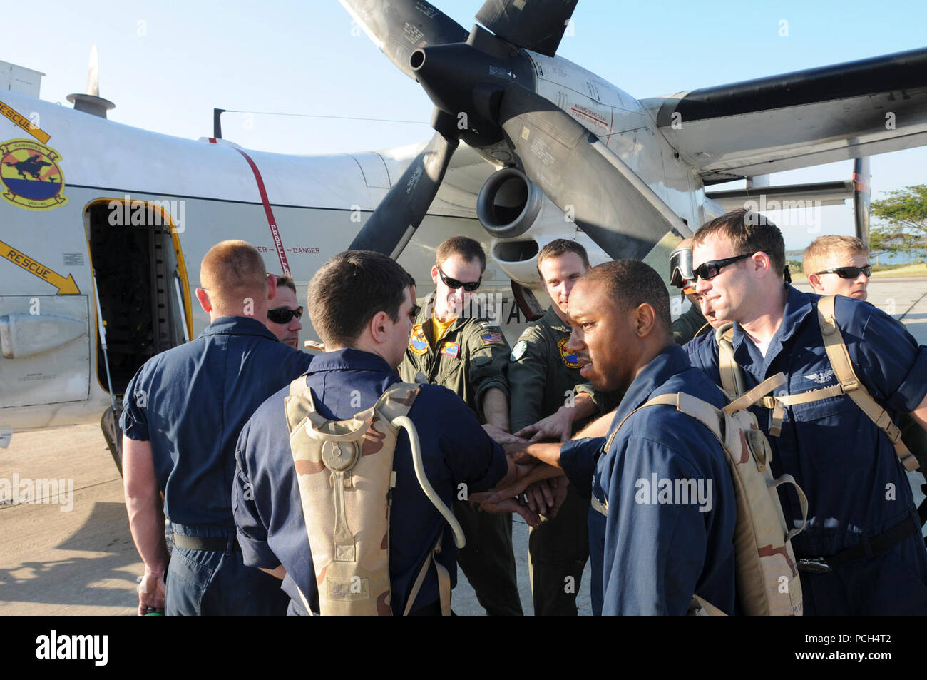 Le Maître de 3e classe de la marine Kenneth Powell, un machiniste aviation mate, dirige un groupe cheer avec son équipage à la station navale des États-Unis à Guantanamo Bay airfield avant de participer à une mission d'assistance humanitaire, le 24 janvier. Les aviateurs, les membres de l'Escadron de soutien logistique de la flotte, sont déployés dans le cadre de l'opération réponse unifiée, fournit de l'aide à Haïti après le séisme du 12 janvier 2010. Banque D'Images
