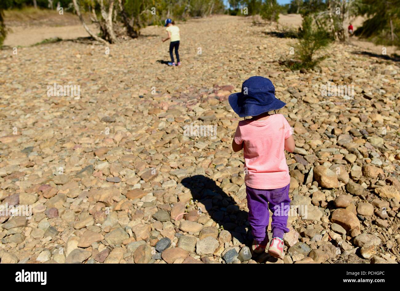 Une jeune fille suit un autre enfant avec un lit, ruisseau, Townsville, Queensland, Australie Banque D'Images