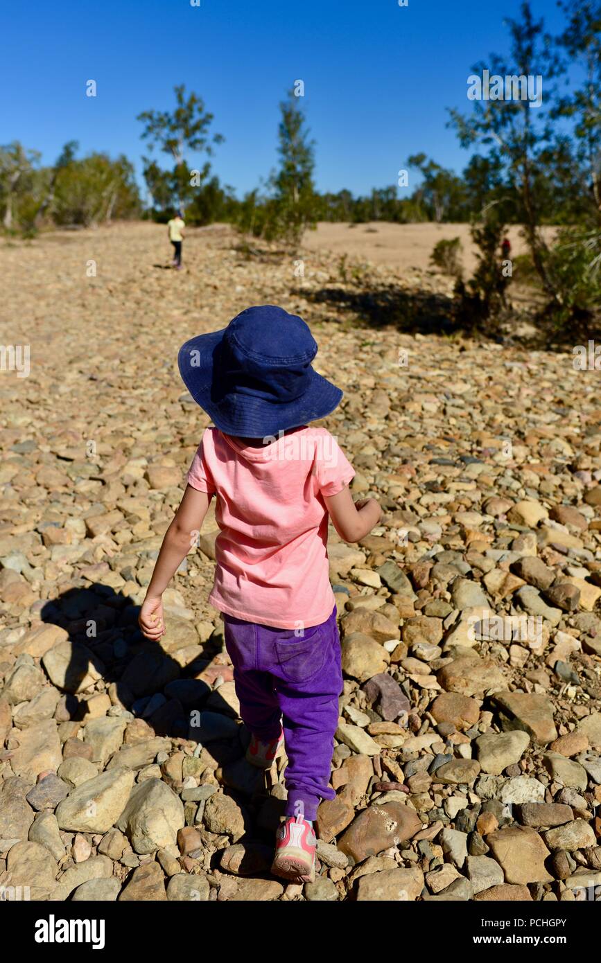 Une jeune fille suit un autre enfant avec un lit, ruisseau, Townsville, Queensland, Australie Banque D'Images