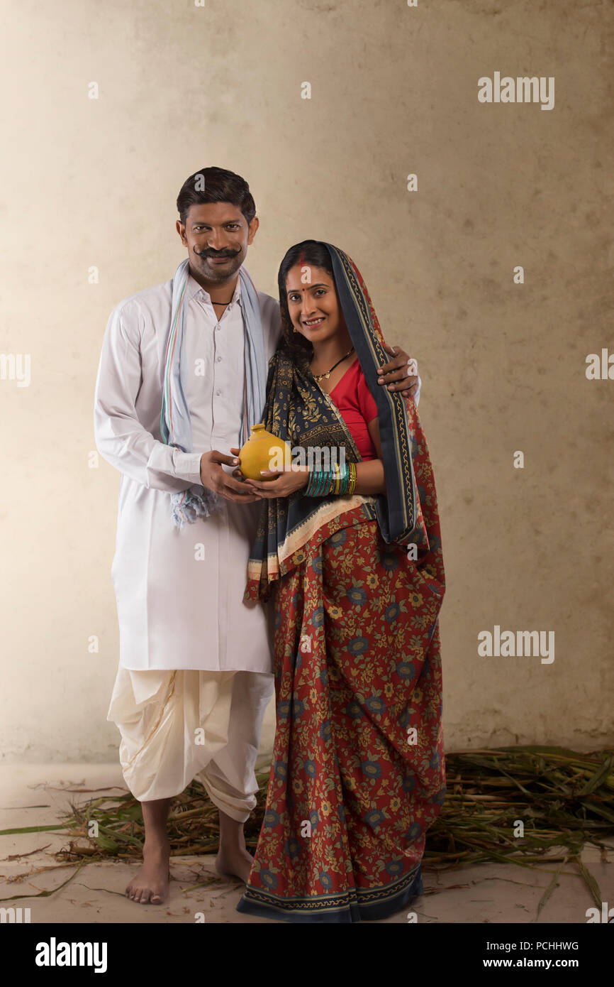 Portrait of Indian couple rural argile holding piggy bank Banque D'Images