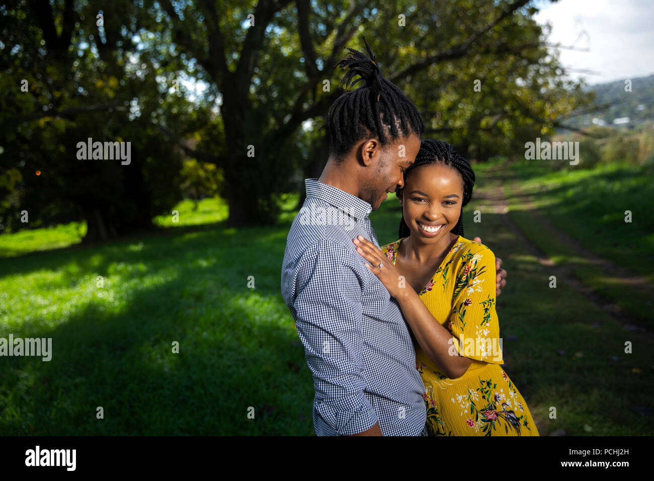 Couple embracing and smiling in a park Banque D'Images