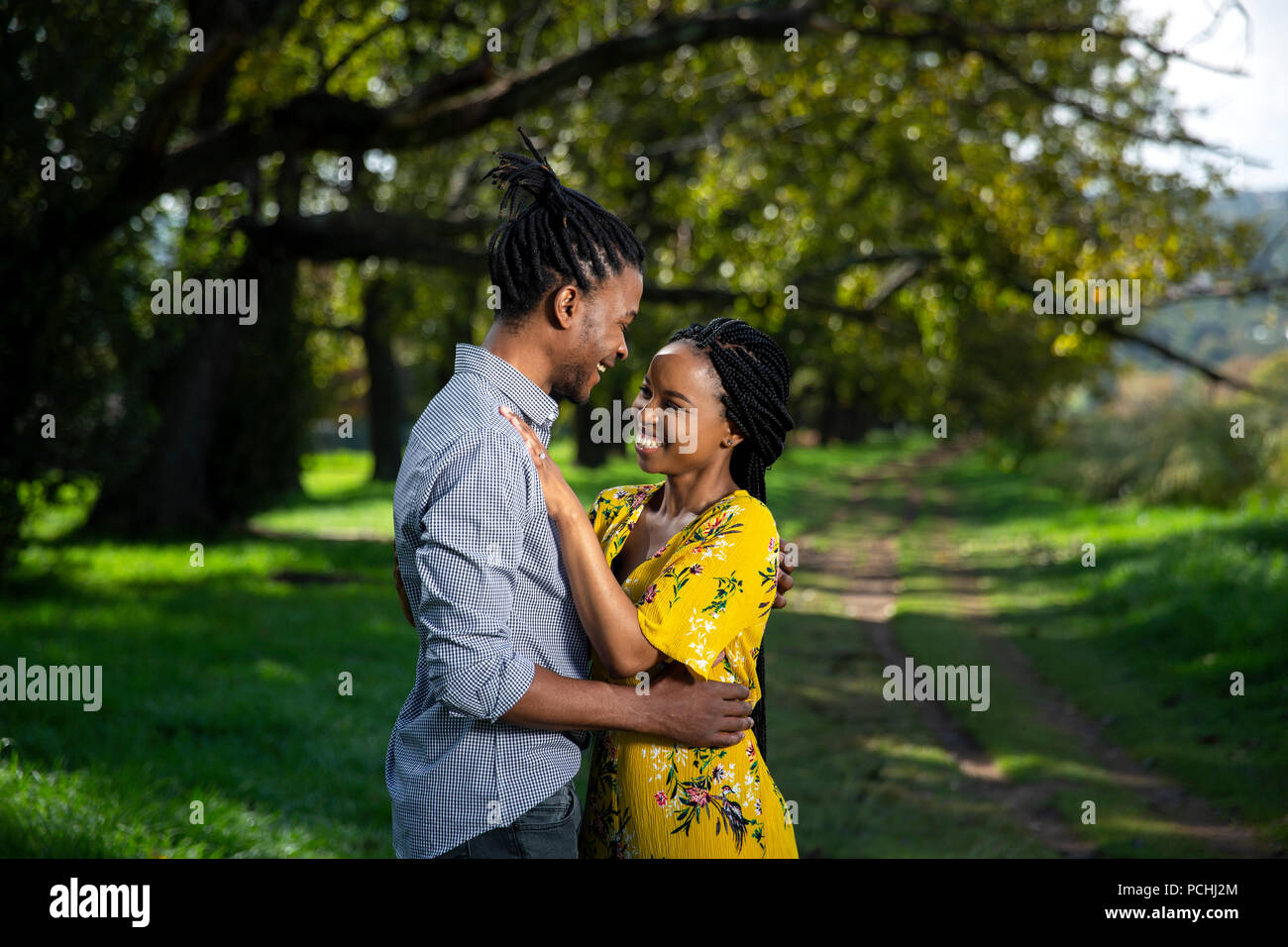 Couple embracing and smiling in a park Banque D'Images