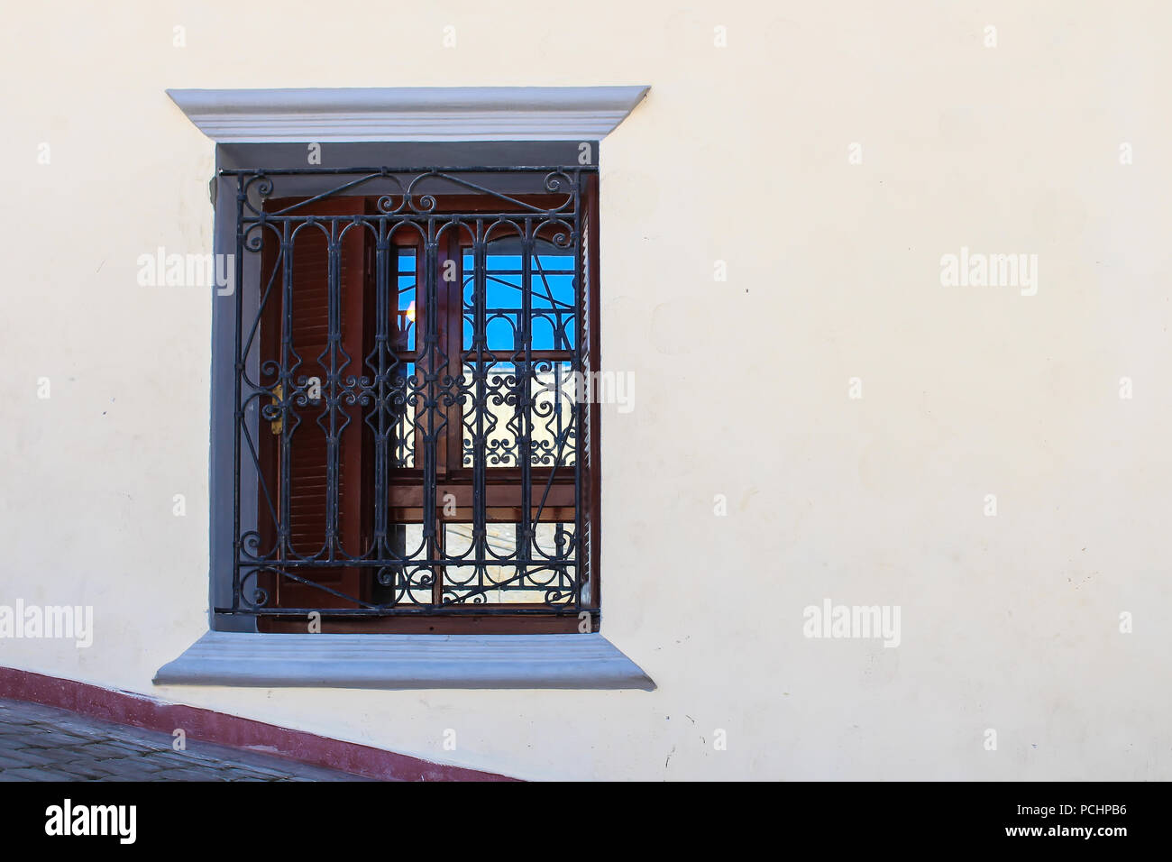 Façade renouvelé d'une maison traditionnelle. Fenêtre avec un reflet dans la vitre. Grille ouvragée traditionnels. Patrimoine portugais à El Jadida, Maroc. Banque D'Images