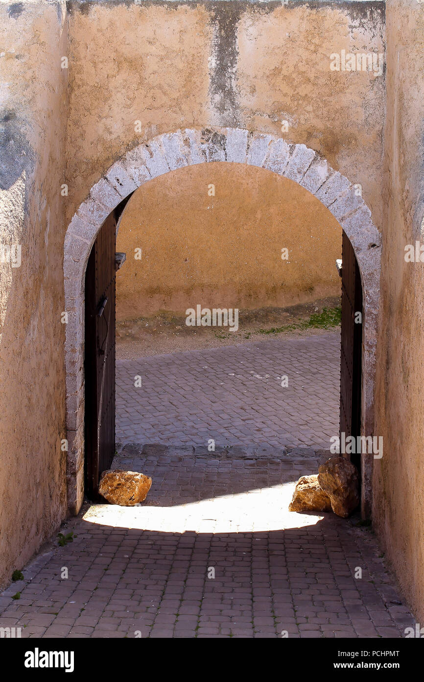 L'une des nombreuses portes de l'enrichissement de l'ancienne forteresse portugaise. Arch et un cadre blanc. Porte en bois ouvert et fixé par de grandes pierres. El Jadida, M Banque D'Images
