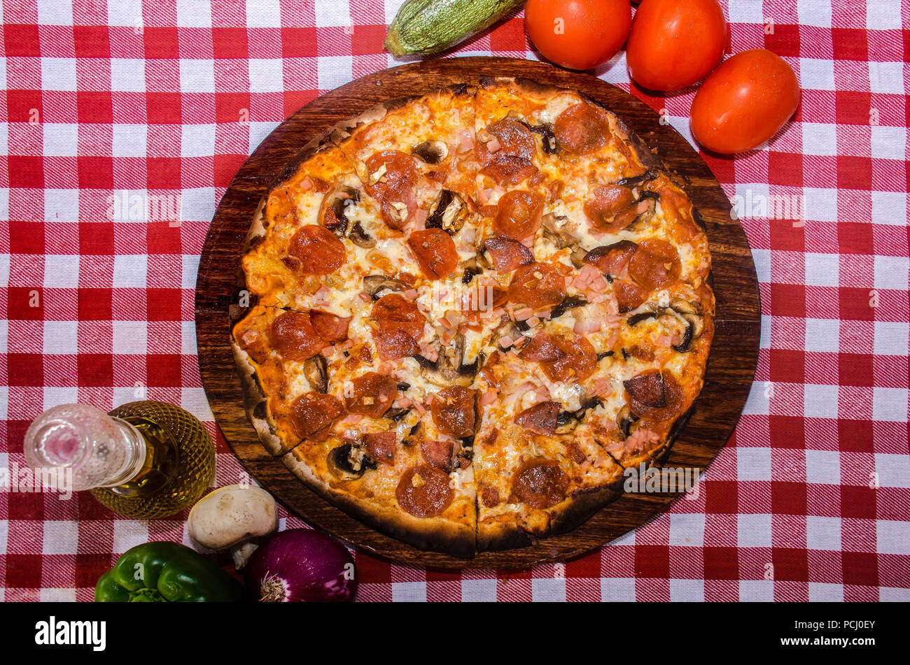 Pizza artisanale sur une plaque de bois Banque D'Images Pizza artisanale sur une plaque de bois Banque D'Images