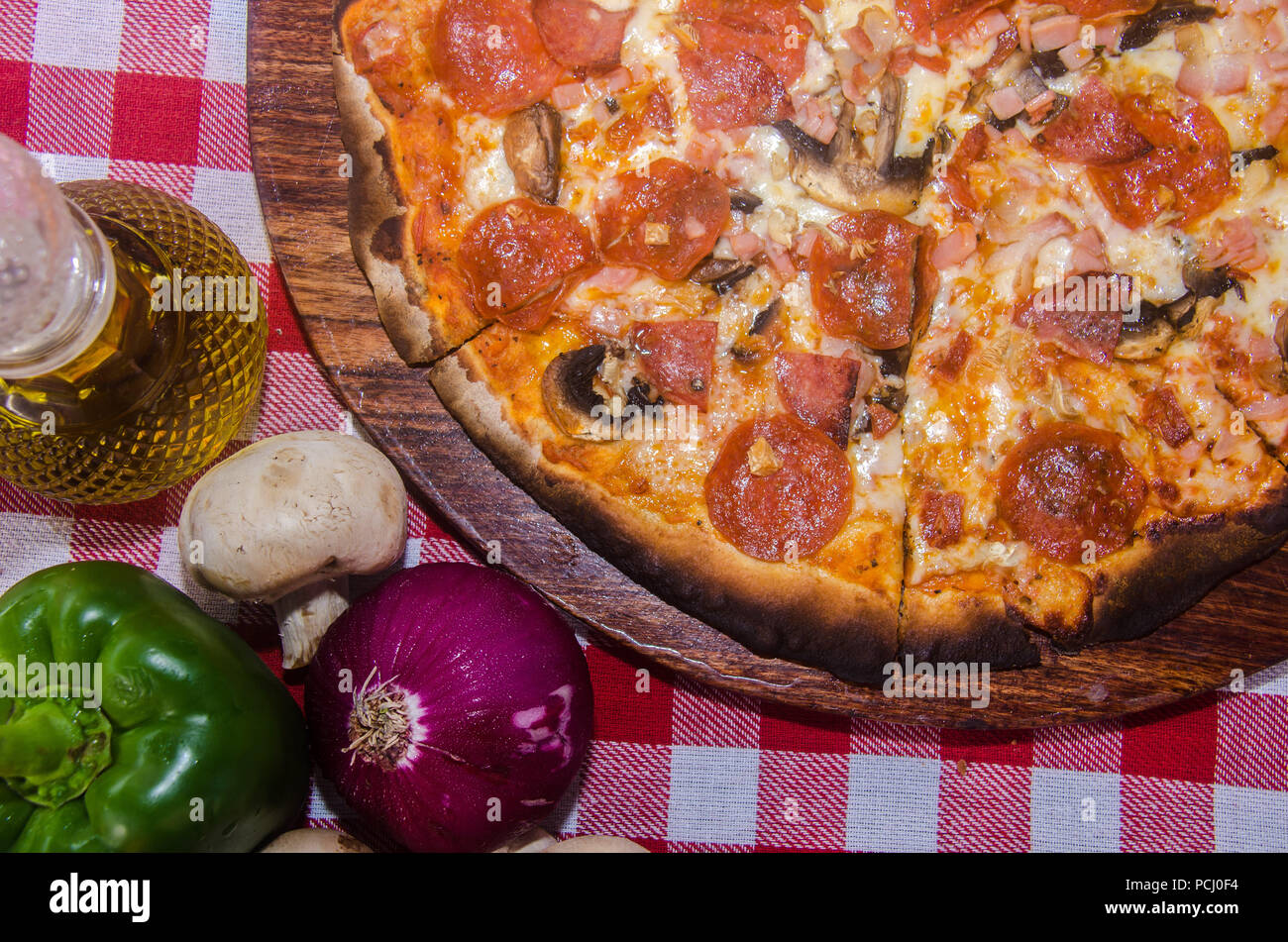 Pizza artisanale sur une plaque de bois Banque D'Images Pizza artisanale sur une plaque de bois Banque D'Images