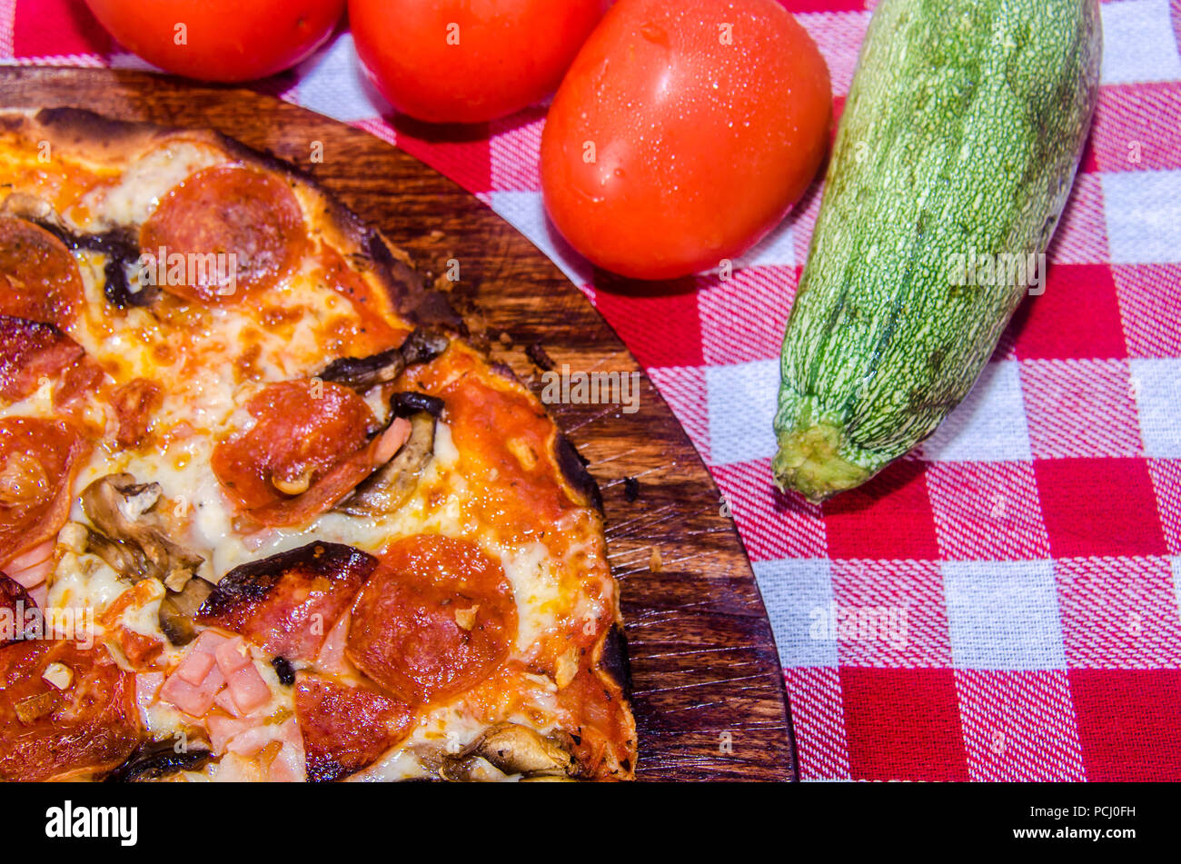Pizza artisanale sur une plaque de bois Banque D'Images Pizza artisanale sur une plaque de bois Banque D'Images