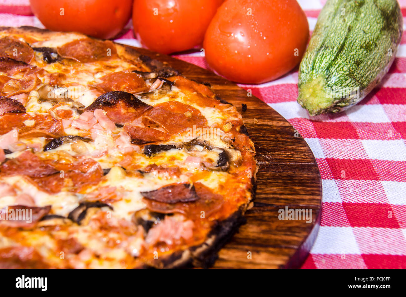 Pizza artisanale sur une plaque de bois Banque D'Images Pizza artisanale sur une plaque de bois Banque D'Images