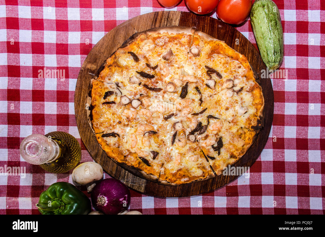 Pizza artisanale sur une plaque de bois Banque D'Images Pizza artisanale sur une plaque de bois Banque D'Images