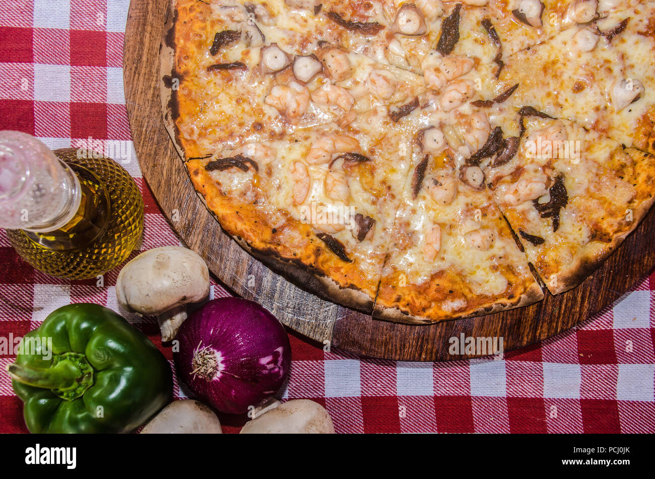 Pizza artisanale sur une plaque de bois Banque D'Images