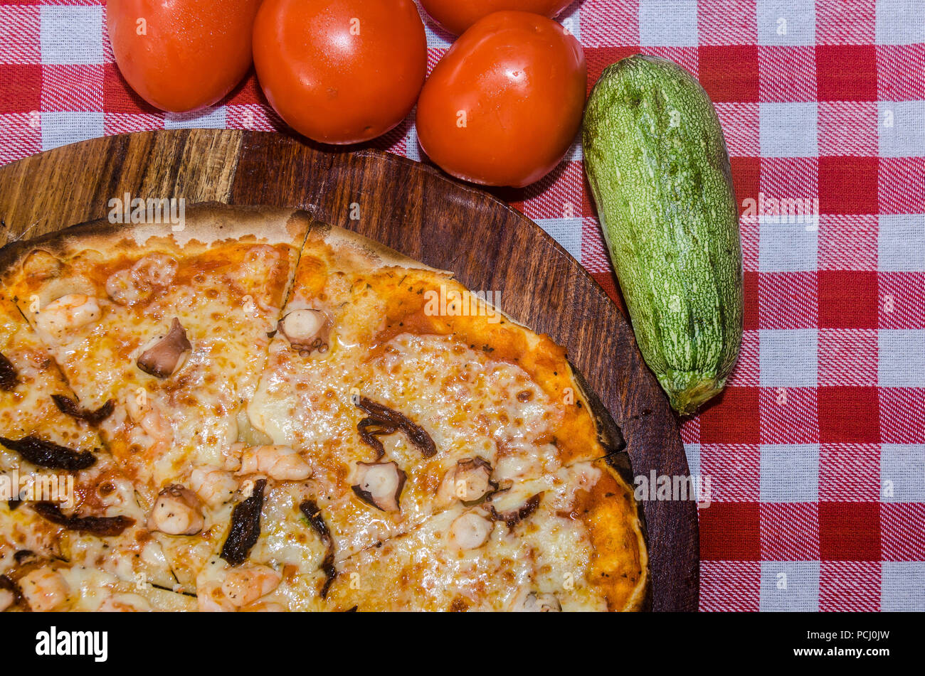 Pizza artisanale sur une plaque de bois Banque D'Images Pizza artisanale sur une plaque de bois Banque D'Images