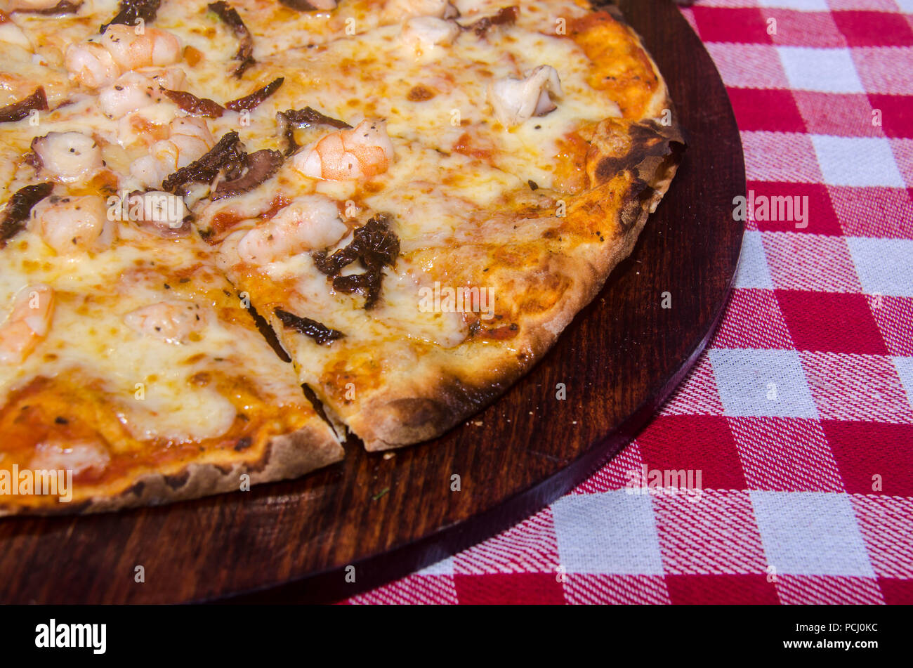 Pizza artisanale sur une plaque de bois Banque D'Images Pizza artisanale sur une plaque de bois Banque D'Images