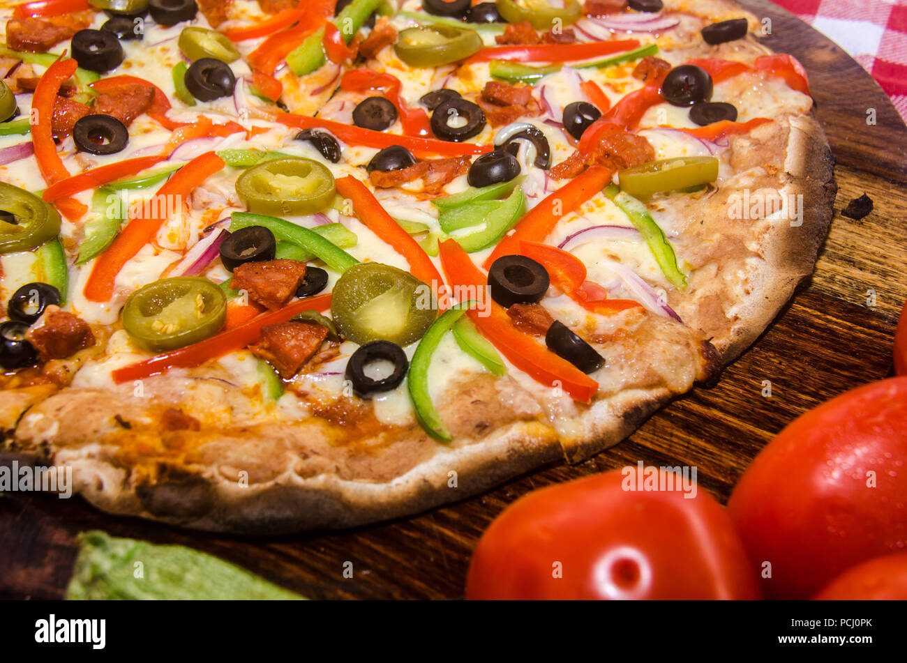 Pizza artisanale sur une plaque de bois Banque D'Images Pizza artisanale sur une plaque de bois Banque D'Images