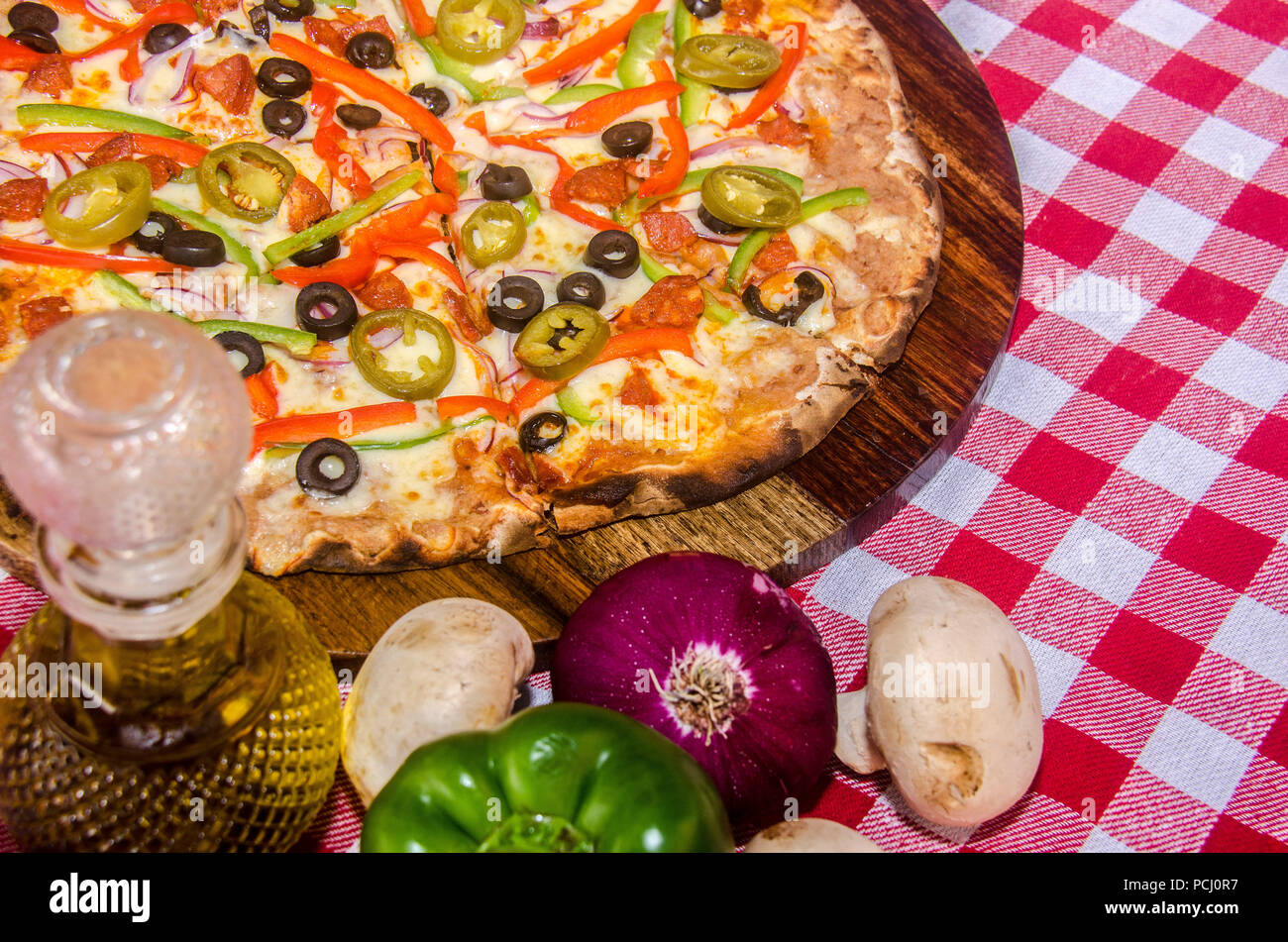Pizza artisanale sur une plaque de bois Banque D'Images Pizza artisanale sur une plaque de bois Banque D'Images