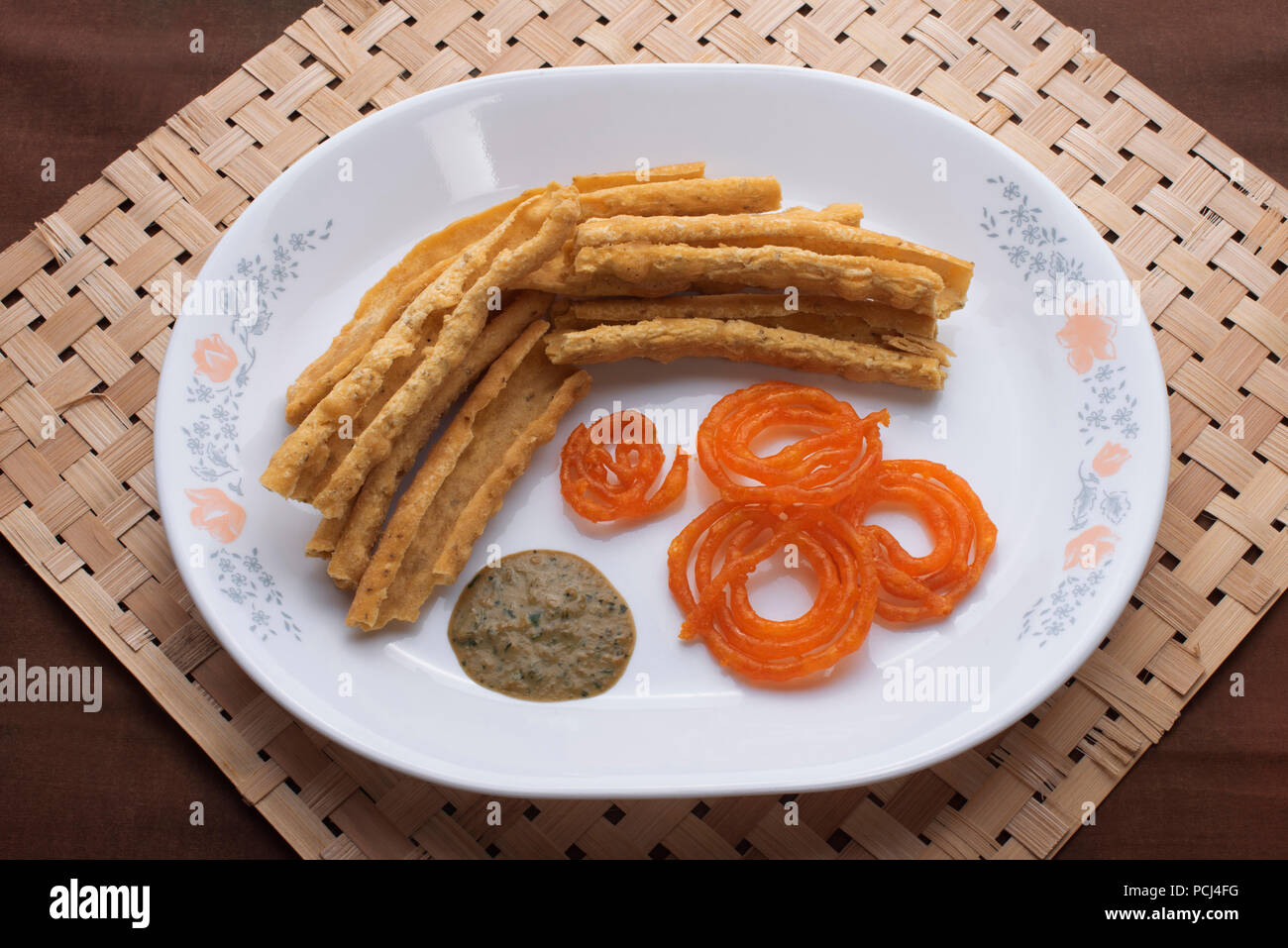 La nourriture traditionnelle indienne, un élément appelé Jalebi Fafda dans une assiette blanche avec chatni vert mangé normalement sur les occasions favorables et les festivals fêtes Banque D'Images