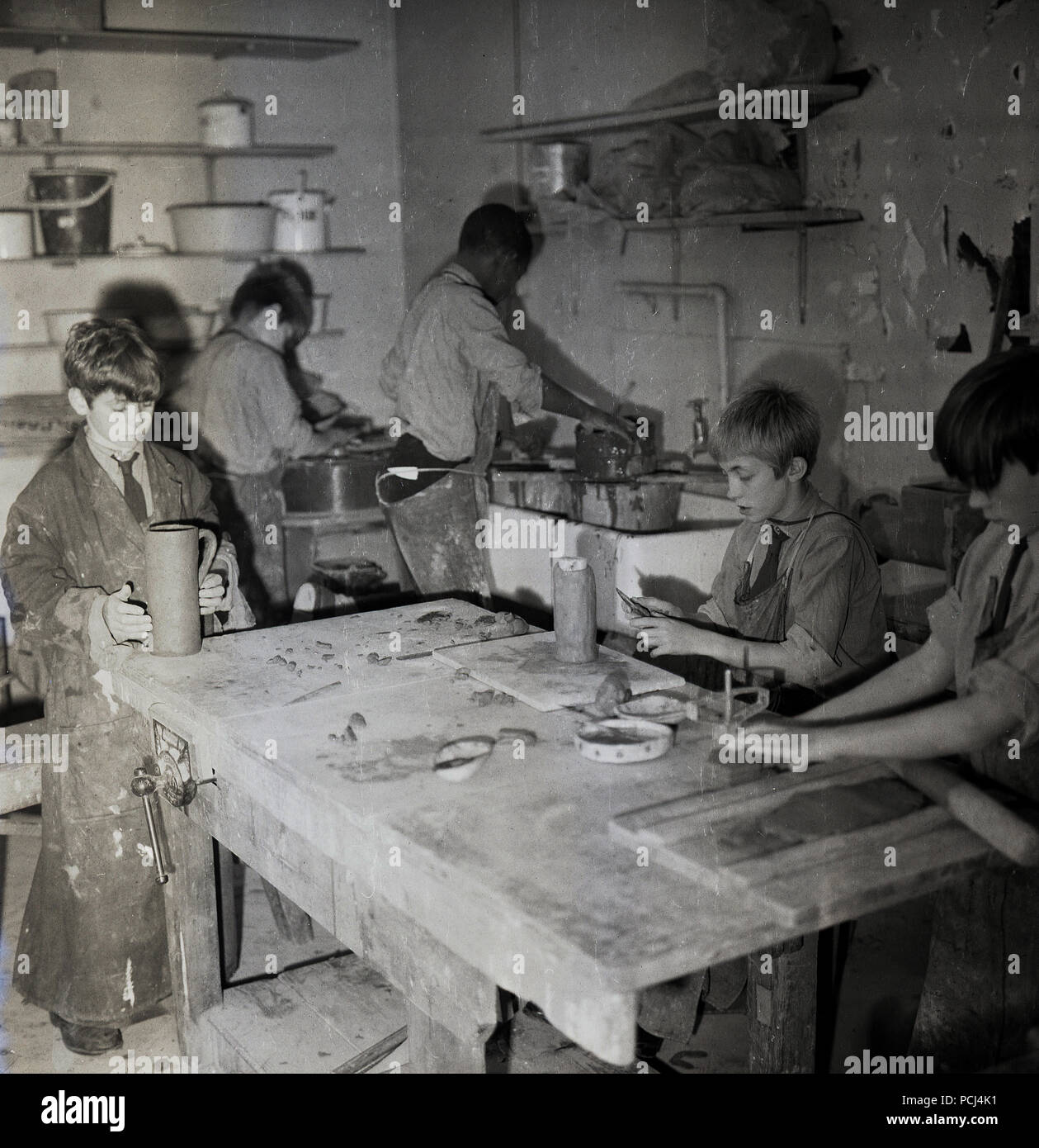 Années 1960, historiques, des écoliers se mélange désordonné de l'argile comme ils participent à une classe de poterie, England, UK. Banque D'Images