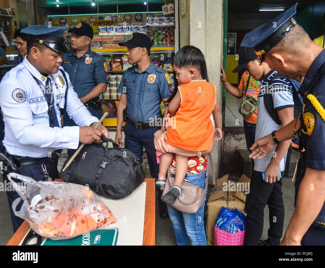 Quezon City, Philippines. 06Th Aug 2018. Alerte renforcée. La police est sur la bonne voie alors qu'il effectuait une inspection des passagers les effets personnels à l'Araneta Cubao, Centre de la station de bus sur le jeudi 2 août 2018. Crédit : Robert Oswald Alfiler/Pacific Press/Alamy Live News Banque D'Images