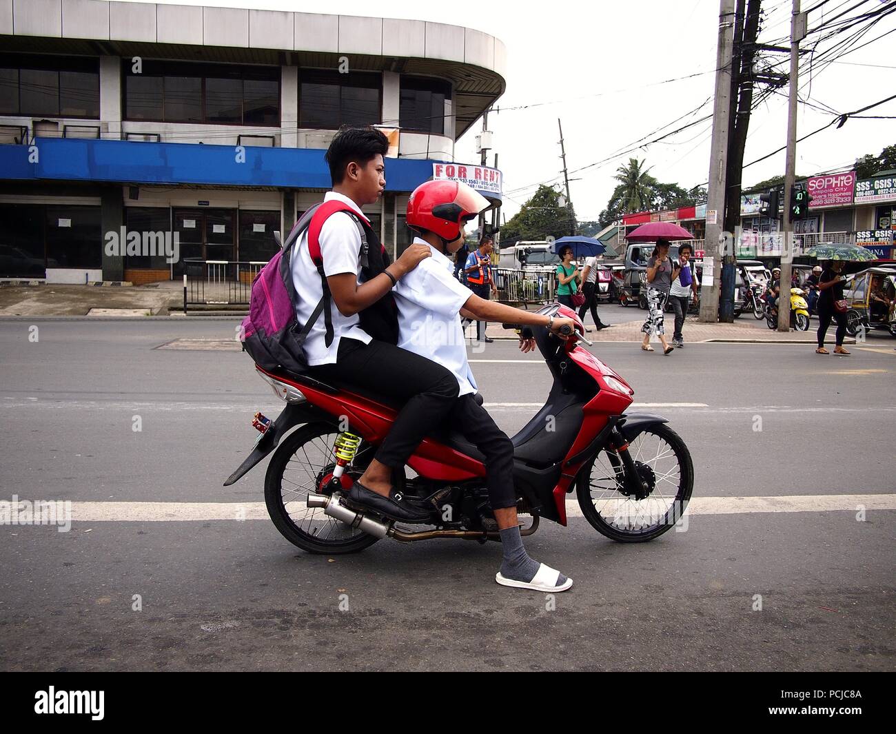 ANTIPOLO CITY, PHILIPPINES - le 26 juillet 2018 : un pilote moto et son passager à une intersection routière. Banque D'Images