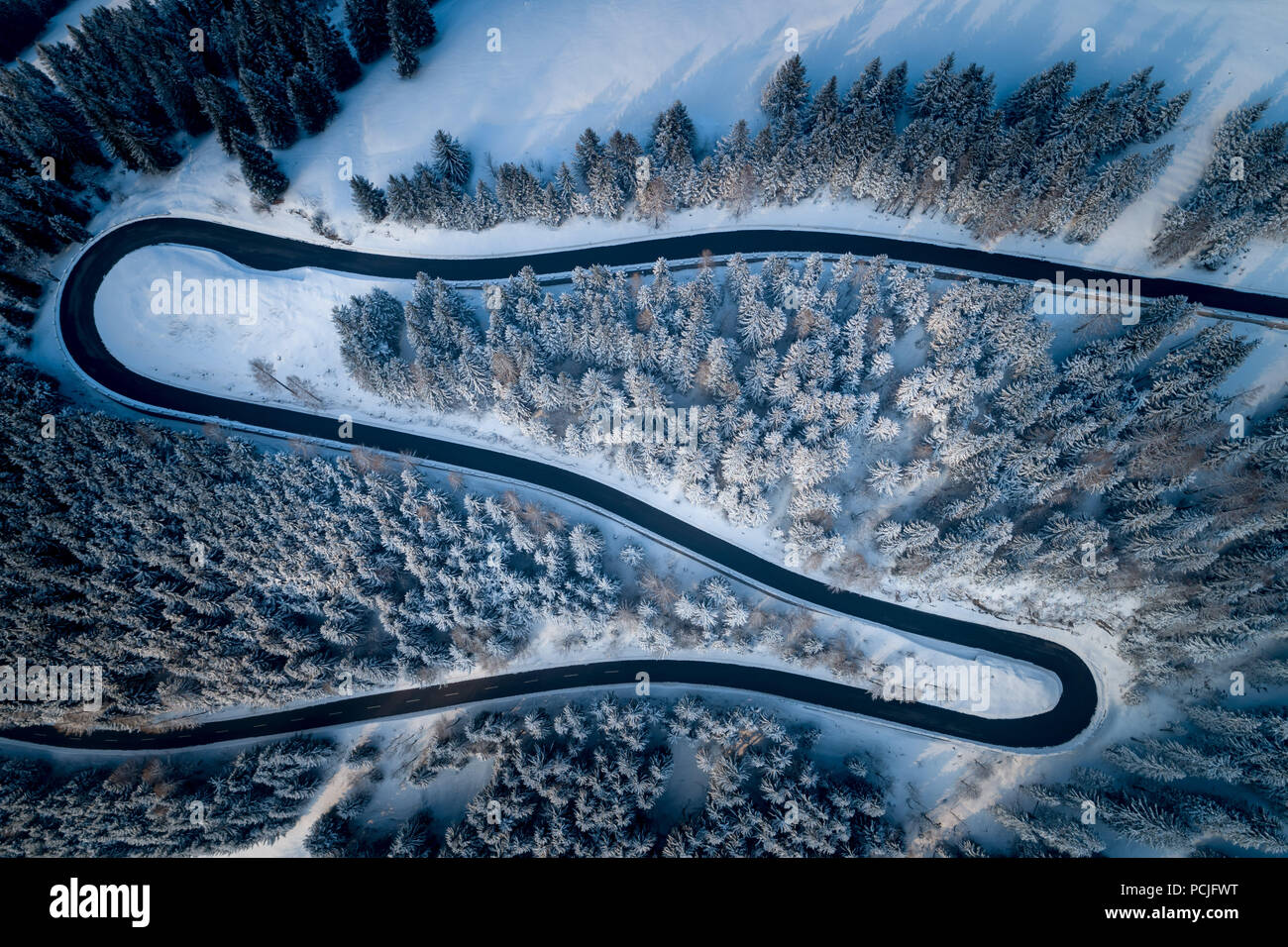 Vue aérienne de route sinueuse à travers les montagnes en hiver, Salzbourg, Autriche Banque D'Images